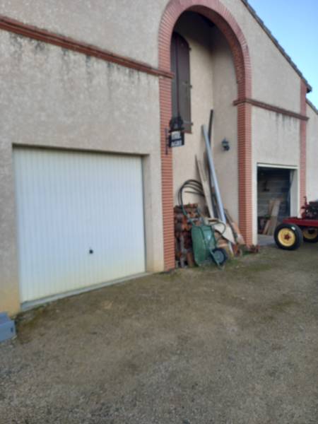 Remplacement de vieilles portes de garage basculantes en acier par des modèles enroulables isolants à Thil. Expertise ML Menuiserie pour une rénovation de façade réussie près de Fonsorbes.