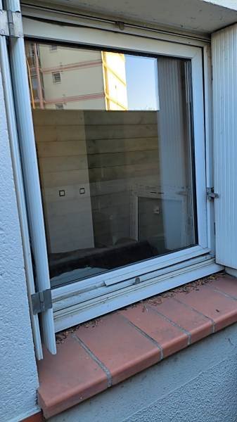 Ancienne fenêtre PVC usagée avant l'intervention de ML Menuiserie à Toulouse (31300). Préparation de la dépose pour une rénovation thermique.