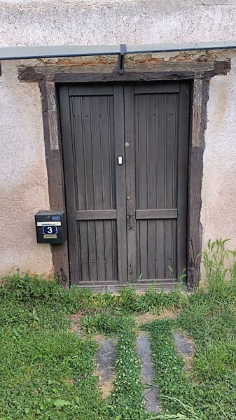 Avant : Une ancienne porte en bois fatiguée et peu isolante.